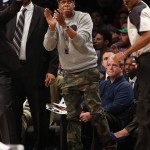 Jay-Z Wears An Adidas Original x Brooklyn Nets Premium Collection Sweatshirt, Balmain Ryan Straight Leg Camo Trouser & Air Jordan IV “Bred”