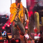Travis Scott Performs In Gucci Snake-appliqué tapered Leg Jeans & A Supreme Uptown Studded Leather Varsity Jacket